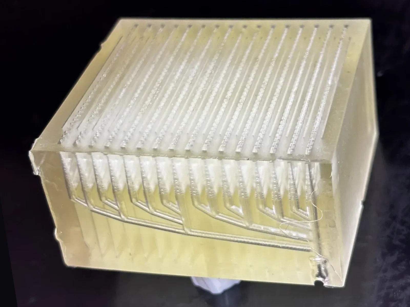 OptiLung prototype: a single clear resin block with rows of blood channels and a branching manifold printed inside.